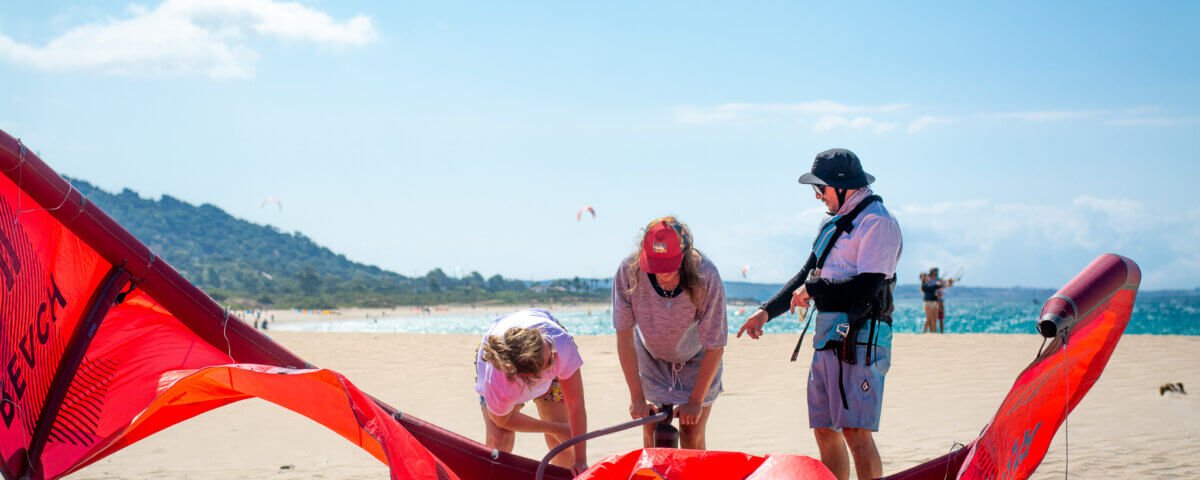 Leçons de kitesurf – Instructeur enseignant à un élève sur la plage