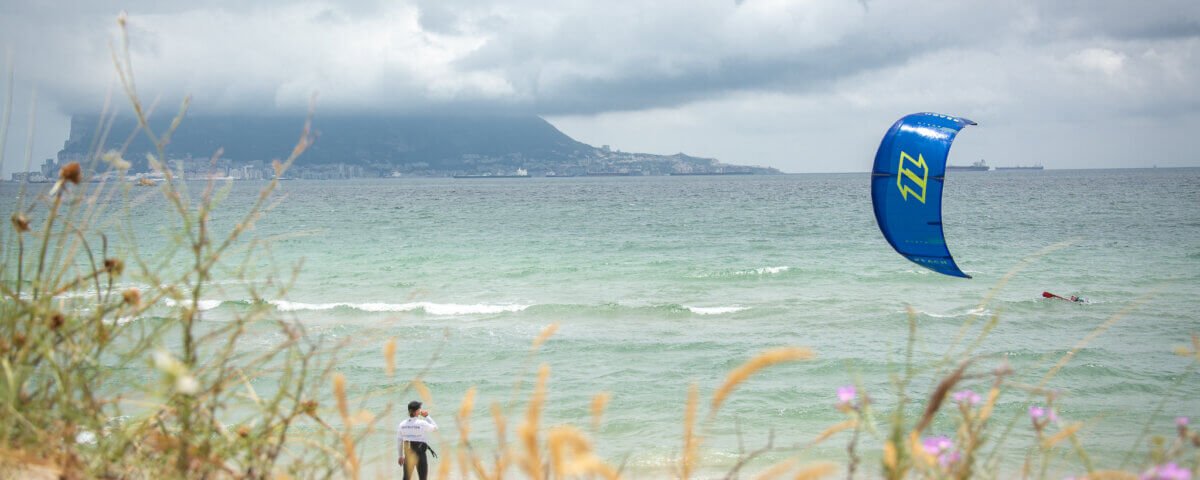 Kitesurfer riding the waves at Playa de Los Lances in Tarifa with blue skies and steady wind