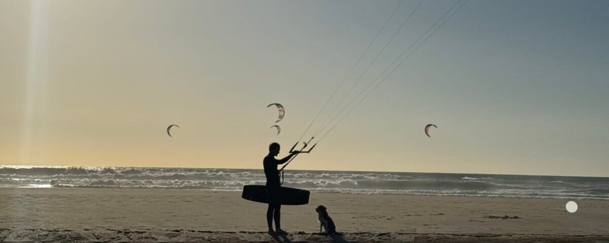 Kitesurfer riding a wave in Tarifa, Spain during sunset – kitesurfing bucket list experience