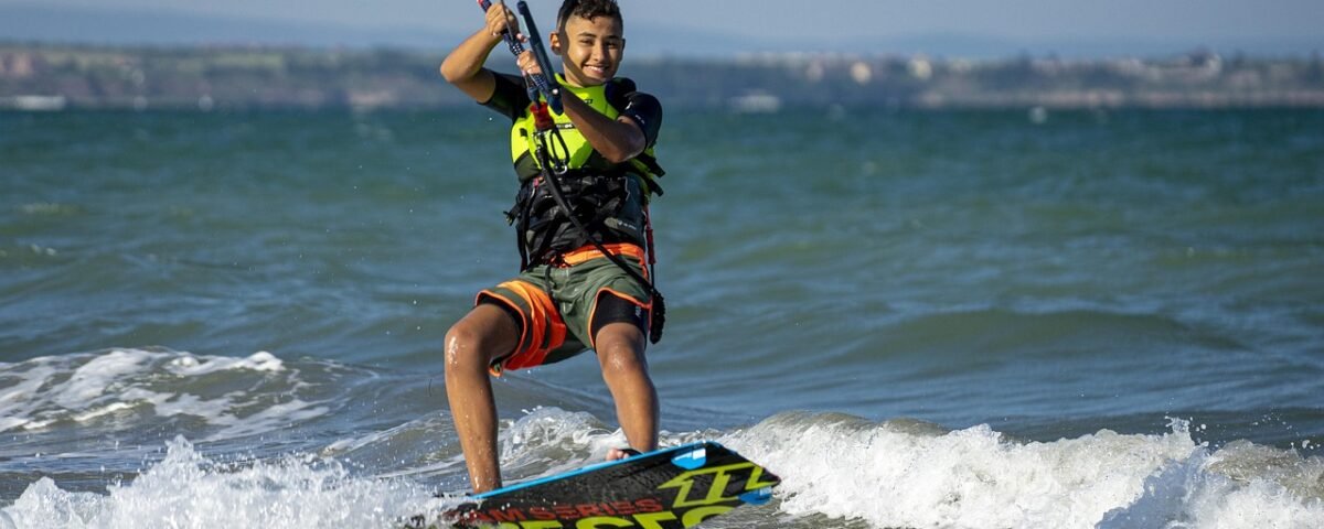 Child learning to kitesurf in Tarifa with a small kite on a sunny day at the beach