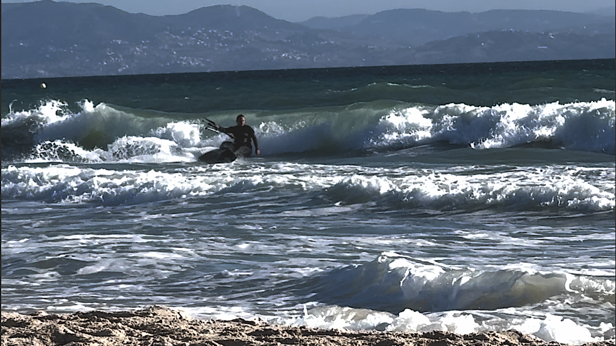 Kitesurfer płynący na falach Oceanu Atlantyckiego w Tarifie podczas dynamicznej sesji na wodzie.